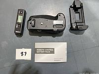 Top view of all components: battery grip, battery tray, remote, manual