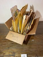 Open cardboard box filled with various sized envelopes and covers