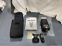 Entire lot showing flash in bag, case, manual, stand, gel filters, battery holder