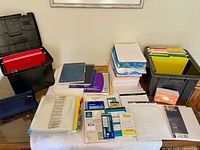 Overview of all office supplies laid out including file folders, paper packs, notebooks, sheet protectors and storage boxes
