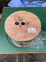 Top of wooden spool showing cable wound beneath plastic wrap
