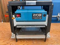 Front view of Ryobi AP-10 planer showing brand badge, power switch, cutter opening