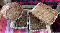 All four baskets grouped on table showing variety: round wicker, rectangular tray, two seagrass baskets