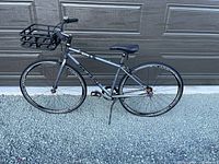 Full left side view of bicycle showing frame, wheels, basket and kickstand