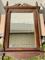 Full view of mirror front showing wood frame and decorative elements