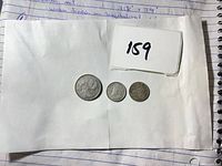 Overall view of three Canadian coins with lot number card