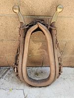 Front view of full horse collar showing leather padding and brass-topped hames