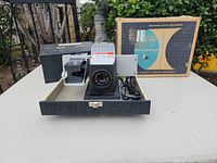 Projector positioned inside open carrying case with original box behind