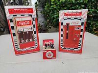 Full lot: two boxed musical banks and miniature clock