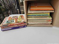 Box and stack of approximately 18 vintage songbooks