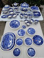 Entire set of blue & white transferware dinnerware and tea service laid out on tables