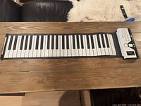 Full view of unrolled 49-key flexible keyboard with control module attached
