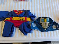 Superman jumpsuit, yellow belt, blue plastic playset piece