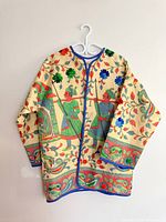 Full view of embroidered coat on hanger