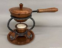 Fondue set fully assembled: saucepan on iron stand with burner cup and underplate