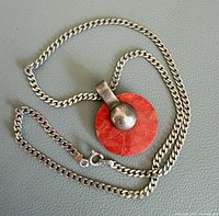 Full view of silver chain and coral pendant