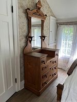 Side view showing dresser, mirror, carved crest, drawers, and shelves