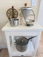 All items on cart including stock pot, strainer set, mixing bowls, trivet
