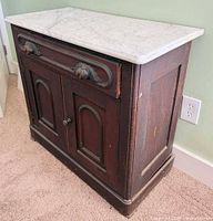 front angle of wooden cabinet with marble top