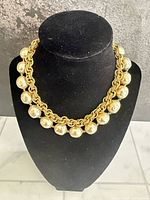 Front view of necklace on display bust showing faux pearls and gilt chain