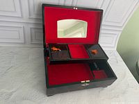 Open jewelry box showing red velvet interior, lift-out tray, mirror