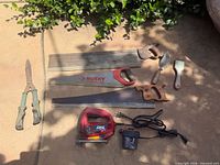 All tools laid out including jigsaw, air pump, hand saws, straightedges, hedge shears, trowel and scraper