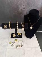 Overall view of jewelry on display stands including necklace, bracelets, earrings, charms and pins