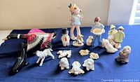 group view of all ceramic figurines on blue cloth