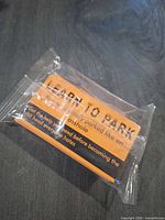 Front view of sealed orange prank parking cards pack