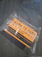 Sealed pack of orange and black parking warning cards