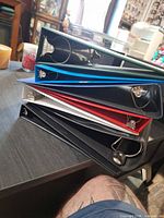 Stack of five binders showing ring hardware and colors