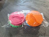 Front view of sealed package showing pink and orange lids