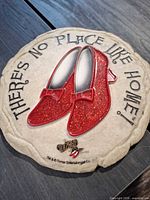 Front view of round plaque showing glitter ruby slippers and text