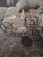 Full side view of metal tricycle plant stand showing overall form and rattan accents