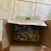 Closed view of cardboard box on scale filled with Pokémon cards