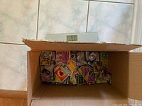 Open box showing pile of loose Pokémon cards and scale reading ~7 lb