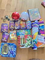 Full lot overview showing Poké Ball tins, binders, minis, window tin, playmats, coins, packs