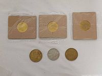 Front view of all six tokens showing three sealed and three loose