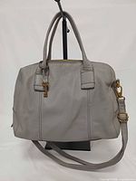 Front view showing overall form, handles, strap, hardware, key charm