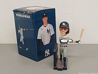 Bobblehead displayed beside original box
