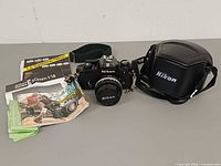Full lot: camera with lens, strap, case, manuals and papers