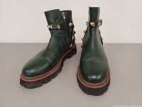 Front and side view of both boots displaying color, studs, and sole