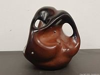Front view showing overall biomorphic shape, glaze, openings
