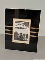 Front view of black acrylic YSL frame with photograph inserted