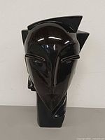 Front view of glossy black ceramic cubist bust