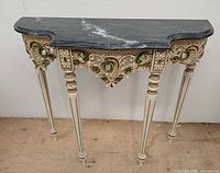 Front view showing carved apron, legs and marble top