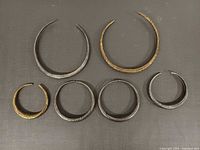 Seven metal chokers and bangles laid out