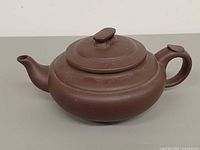Side view showing overall form, spout, handle, lid