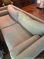 Top view of sofa showing seat and back cushions, bolster pillows, upholstery texture