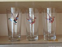 Three glasses showing duck-like birds, gold rims visible